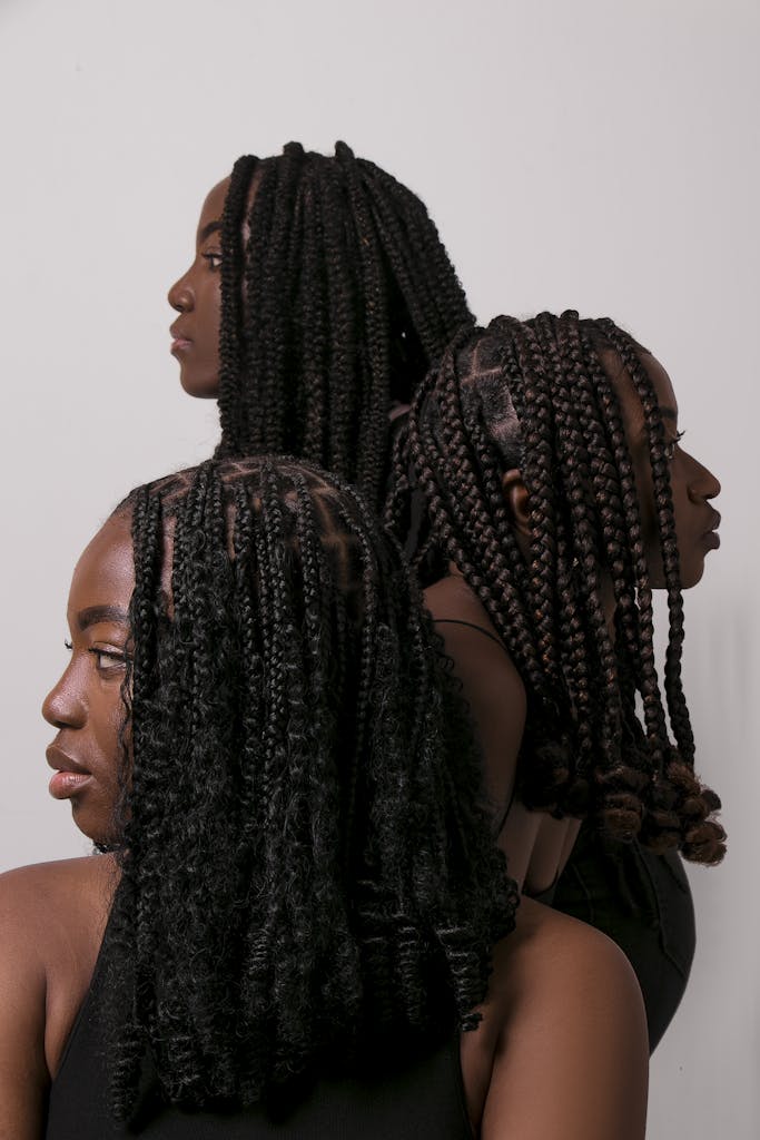Stylish portrait of three women showcasing a variety of intricate braided hairstyles, exuding elegance.
